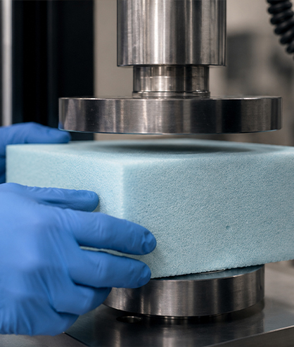 Un pezzo di plastica flessibile viene messo sotto una pressa per essere testato.